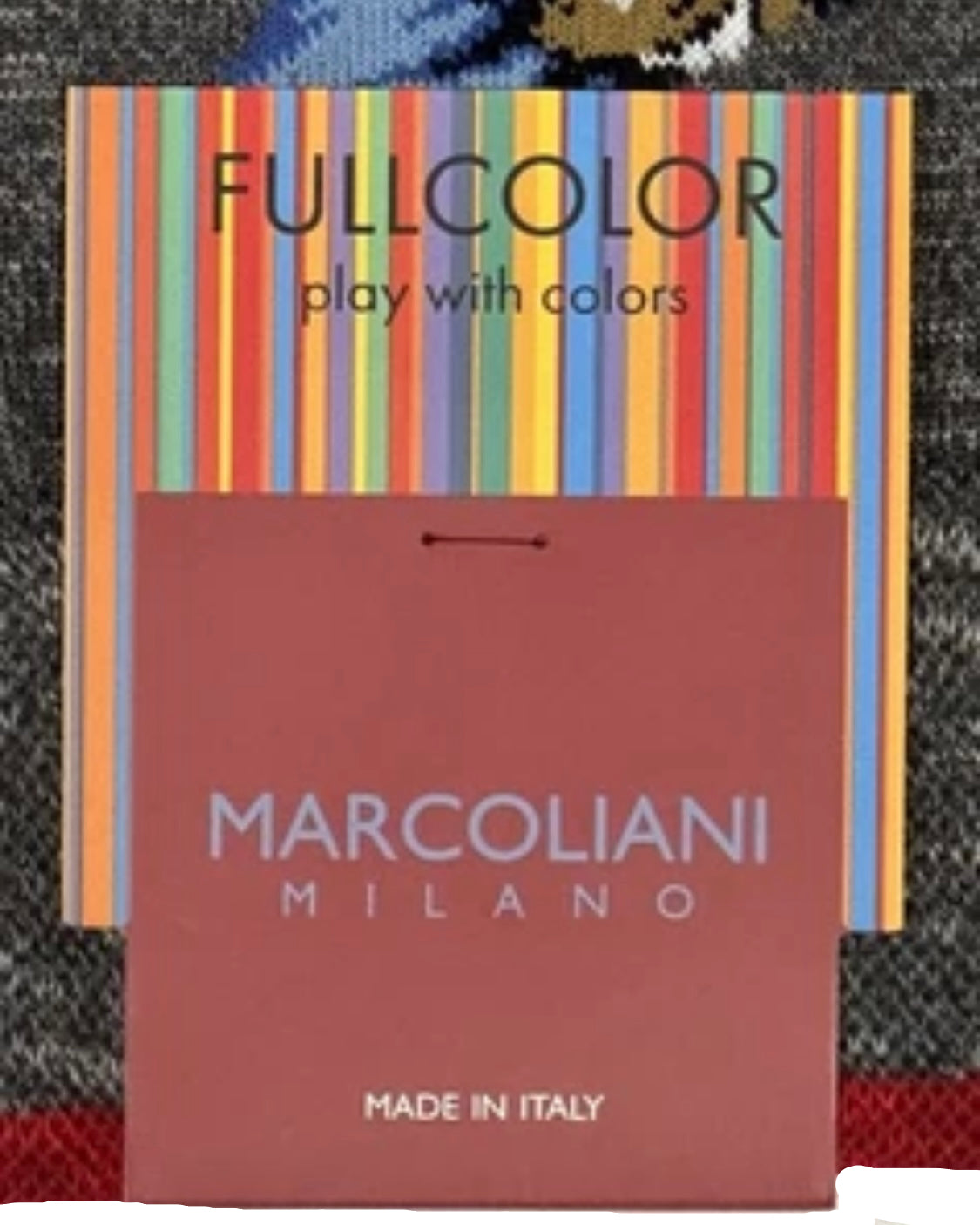 Marcolianidi Milano packaging with colorful stripes and text on a textured background